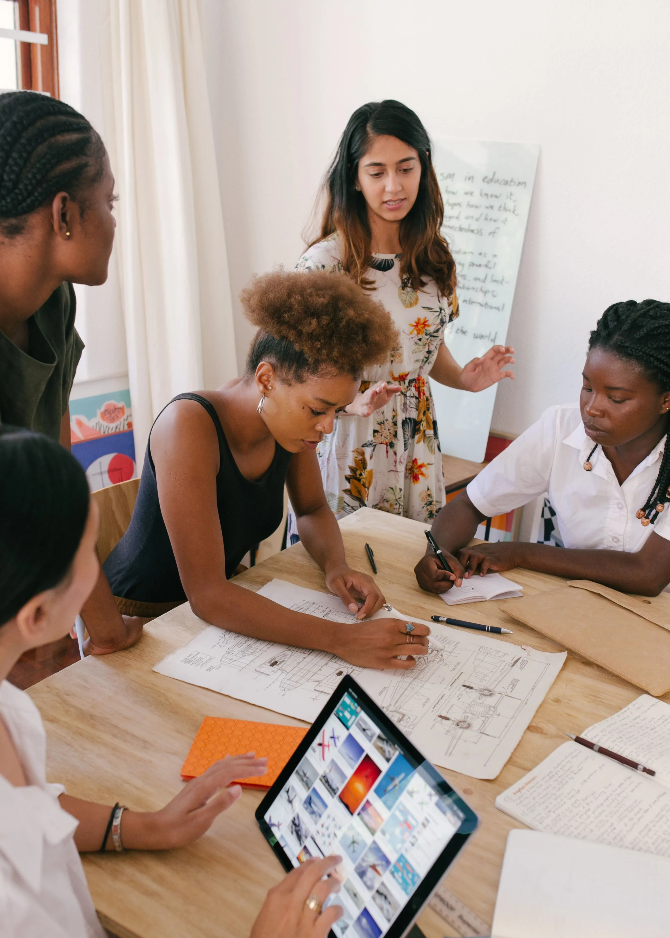 A community group gathered around a table, planning a program together on paper